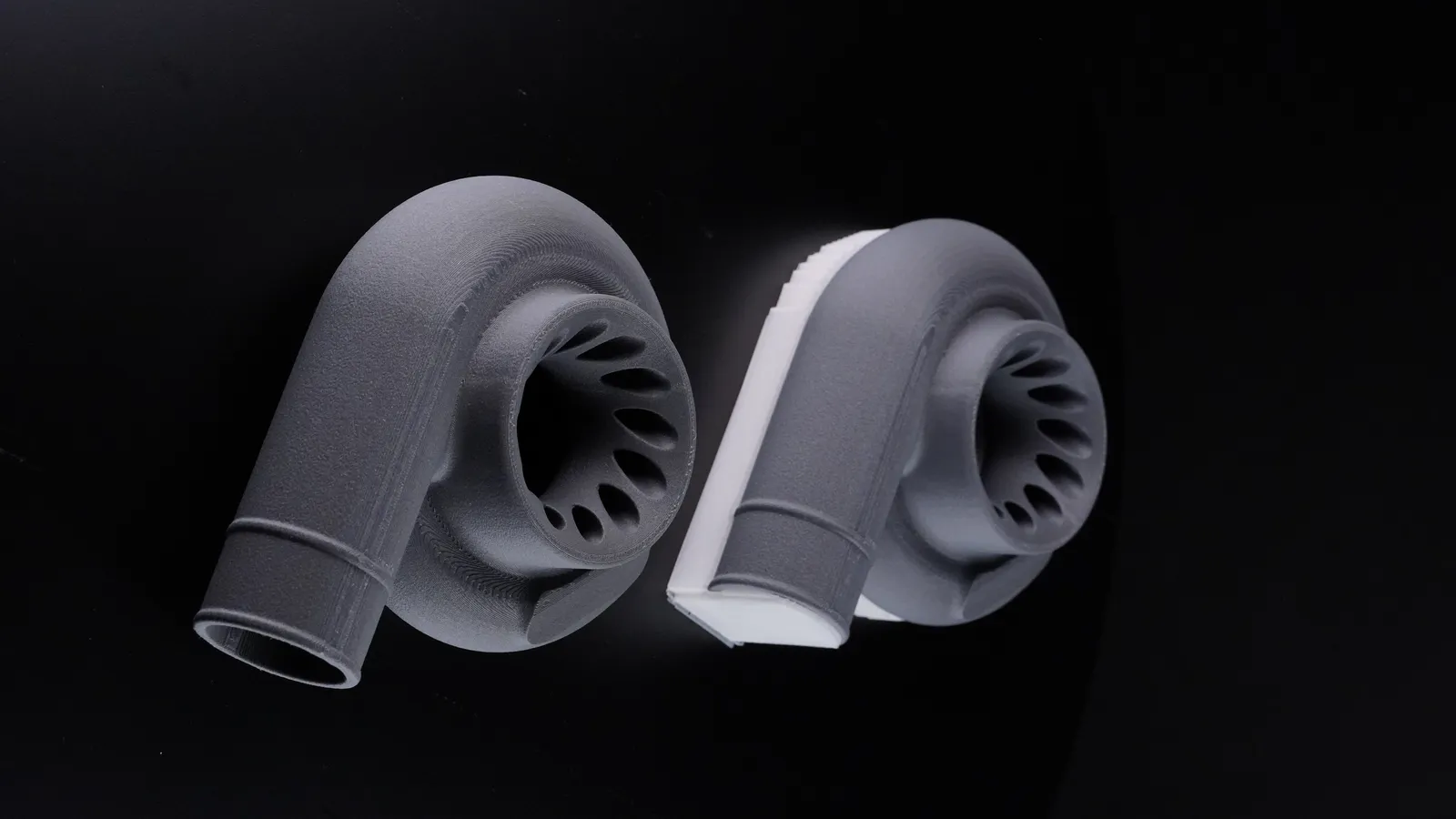 3D printed turbo housings, one wearing white VXL 111 support